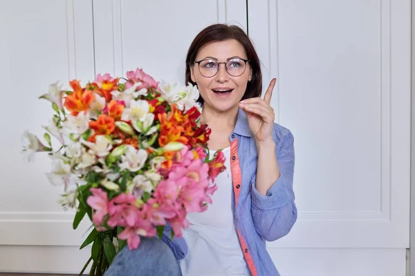 Portret van mooie volwassen vrouw met boeket bloemen — Stockfoto