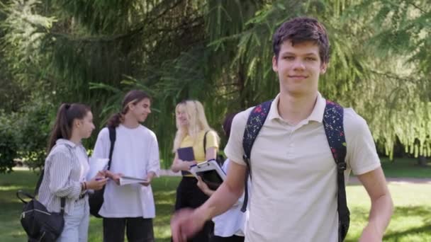 Mannelijke student 16, 17 jaar met rugzak, in schoolpark — Stockvideo