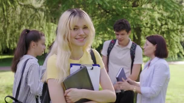 Studentka 16, 17 let s digitálním tabletovým batohem, ve školním parku — Stock video