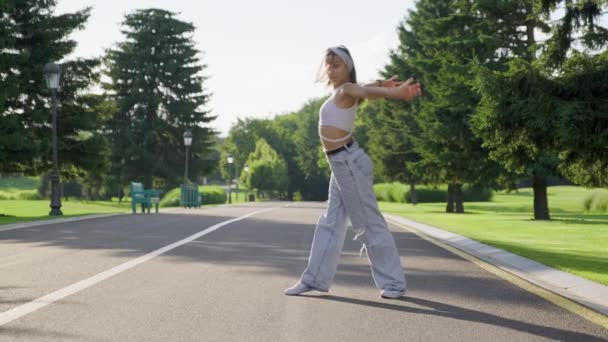 Tanzende junge Teenagerin im Park unterwegs — Stockvideo