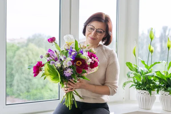 美しいです成熟した女性の肖像-自宅で花束 — ストック写真