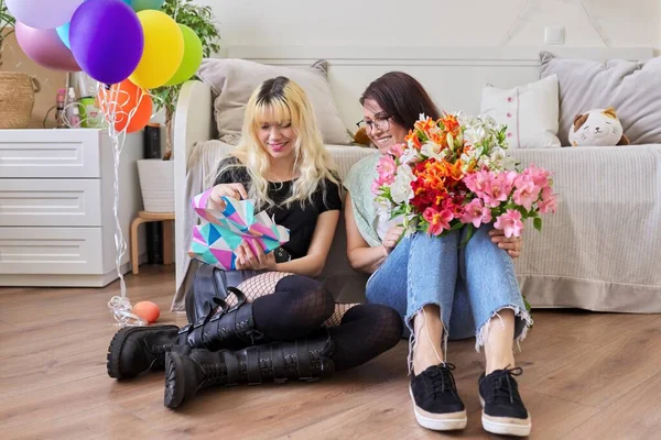 Mamá felicitando a la hija con ramo de flores y caja de regalo sorpresa —  Fotos de Stock