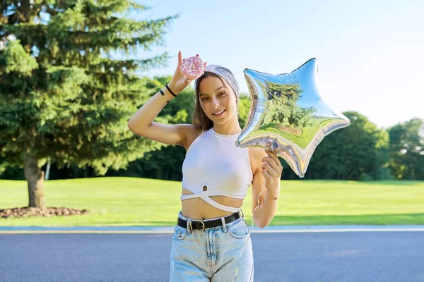 Menina bonita na moda adolescente com donut doce e estrela de balão — Fotografia de Stock