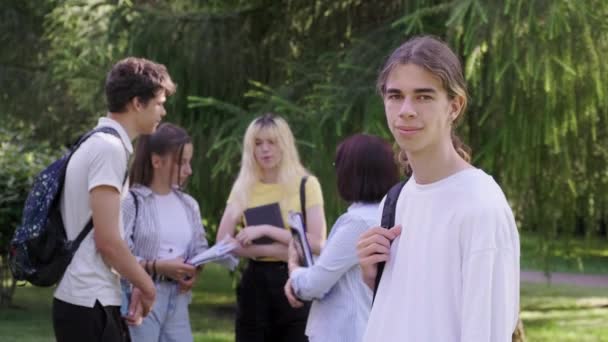 Hombre estudiante 16, 17 años con mochila, en el parque escolar — Vídeo de stock