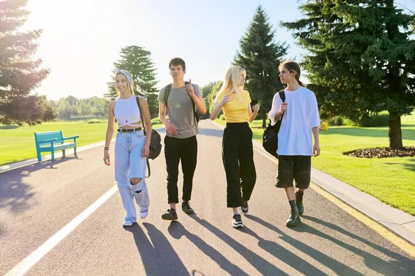 Na zewnątrz, czterech nastolatków spacerujących razem po drodze — Zdjęcie stockowe