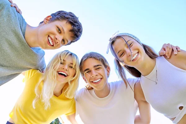 Zbliżenie uśmiechniętych nastolatków. Przytulanie nastolatków patrzących w kamerę, tło nieba. — Zdjęcie stockowe