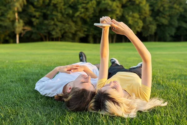 Heureux couple d'adolescents sur l'herbe verte — Photo