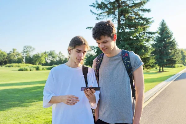 Adolescentes amigos hablando mirando la pantalla del teléfono inteligente — Foto de Stock