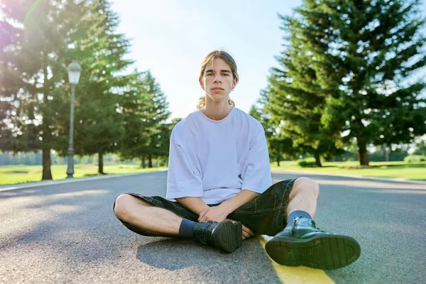Divat portré hipster tinédzser srác ül az úton. — Stock Fotó