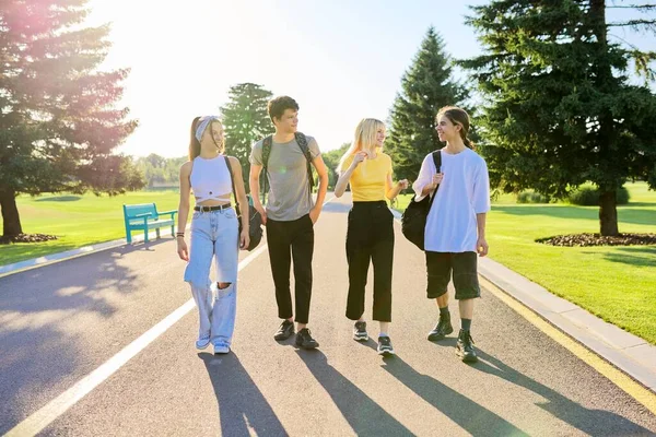 Na zewnątrz, czterech nastolatków spacerujących razem po drodze — Zdjęcie stockowe