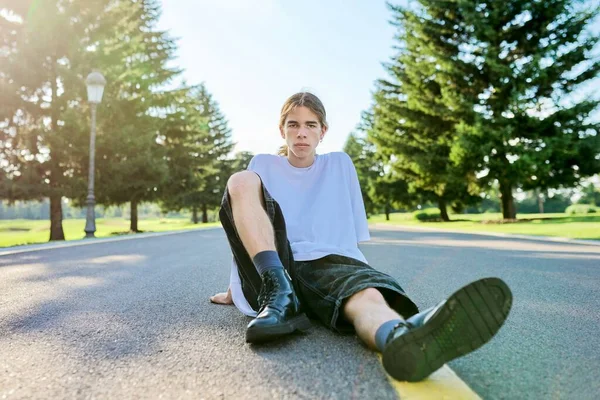 Divat portré hipster tinédzser srác ül az úton. — Stock Fotó