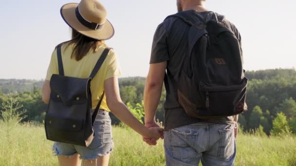 Glad medelålders par hålla händer, man och kvinna med ryggsäckar, baksida — Stockvideo