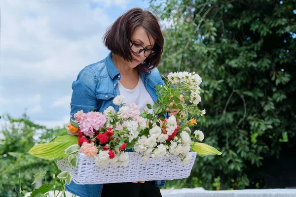 Vrouwelijke bloemist werken met bloemen buiten, het versieren van evenementen met bloemen — Stockfoto