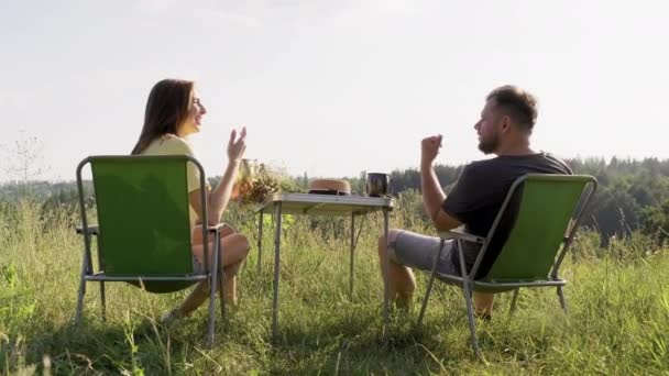 Medelålders par som vilar i naturen, sitter på fåtöljer — Stockvideo
