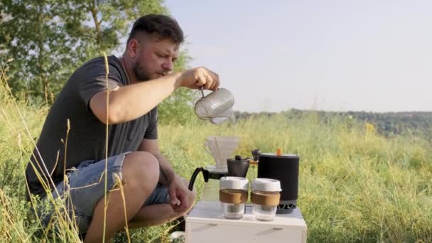 Medelålders man gör kaffe i naturen, sommar solig dag — Stockvideo