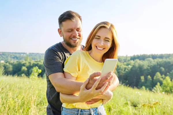 Hermosa pareja adulta feliz tomando selfie en el teléfono inteligente —  Fotos de Stock