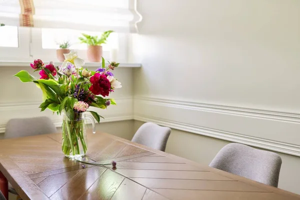 Bukiet jasnych kwiatów na stole w dzbanku — Zdjęcie stockowe