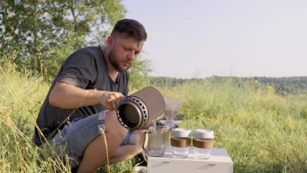 Medelålders man gör kaffe i naturen, sommar solig dag — Stockvideo