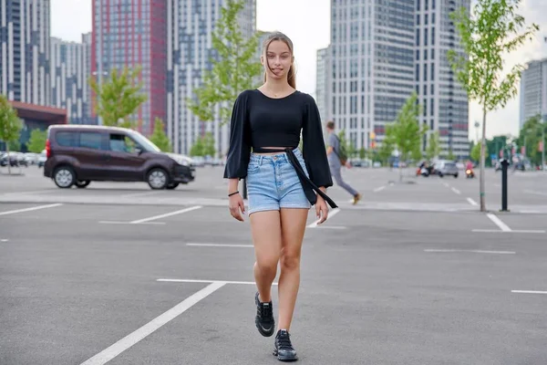 Correndo elegante menina adolescente, arquitetura urbana moderna estacionamento fundo — Fotografia de Stock