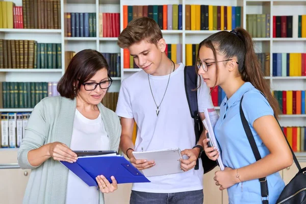 Students teenagers talking with woman teacher mentor — Stock Photo, Image