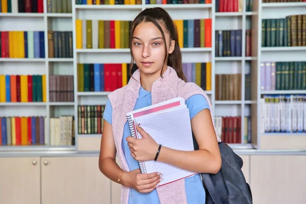 Portret nastolatki oglądającej kamerę, tło wnętrza biblioteki — Zdjęcie stockowe