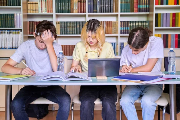 Grupo de estudiantes adolescentes que estudian en la biblioteca escolar. — Foto de Stock