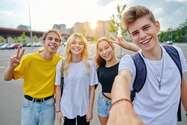 Sorrindo grupo de adolescentes tomando selfie, feliz quatro adolescentes olhando para a câmera — Fotografia de Stock