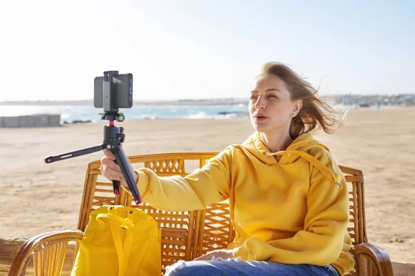 Femme d'âge moyen faisant appel vidéo en ligne parler rire, coucher de soleil fond marin — Photo