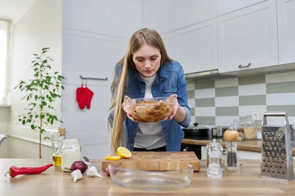 Ung kvinna i hemmet kök matlagning kött, kyckling — Stockfoto