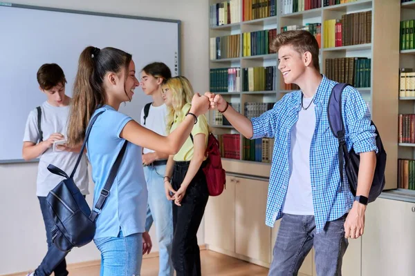Группа подростков ребята и девочки приветствуются, встреча, улыбаясь, радуясь внутри школы — стоковое фото