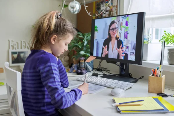 Child girl studying with teacher remotely on computer using video call — Stock Photo, Image