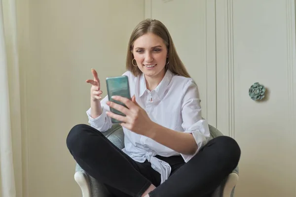 Emocionální mladá krásná žena při pohledu na obrazovce smartphone — Stock fotografie