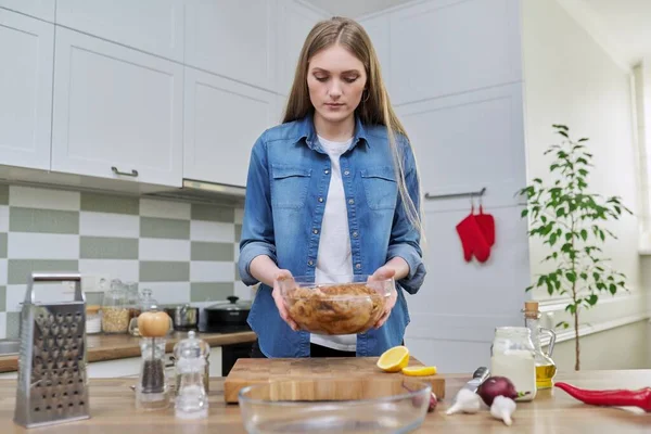 Молодая женщина на домашней кухне готовит мясо, курицу — стоковое фото