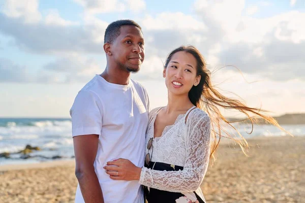 Amar romántico abrazando joven pareja multiétnica en la orilla del mar —  Fotos de Stock