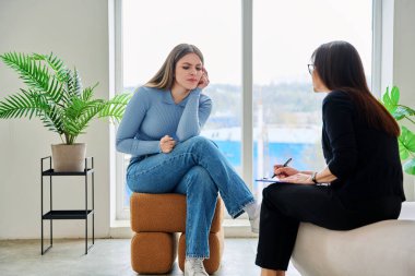 Terapi seansında psikoterapist psikolog psikanalist sosyal hizmet uzmanıyla konuşan genç bir kadın. Ruh sağlığı, profesyonel psikolojik danışmanlık, gençlik öğrencileri için sosyal hizmetler