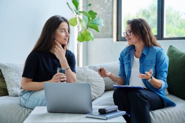 Terapi seansında genç gülümseyen kız hasta psikolog sosyal terapist ile birlikte kanepede oturuyor. Sağlık hizmeti gençlik yardımı, psikolojik hizmetler, psikoterapi