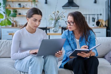 Dizüstü bilgisayarı olan genç bir kızla birlikte çalışan sosyal hizmet uzmanı bir kadın. Ev ziyareti anketi danışmanlığı. Psikolojik sosyal hizmetler, psikoterapi tedavisi desteği