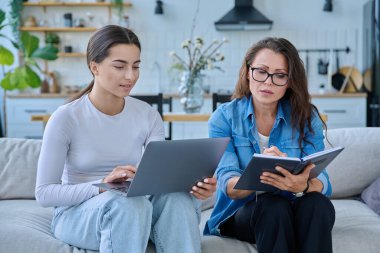 Dizüstü bilgisayarı olan genç bir kızla birlikte çalışan sosyal hizmet uzmanı bir kadın. Ev ziyareti anketi danışmanlığı. Psikolojik sosyal hizmetler, psikoterapi tedavisi desteği