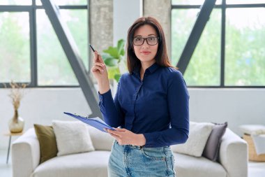 Ofisinde kanepede panosu olan kendine güvenen bir kadının portresi. Gülümseyen kadın psikolog psikoterapist danışman sosyal hizmet yöneticisi öğretmen akıl hocası iş kadını