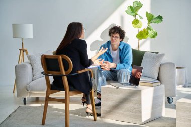 Akıl hastanesindeki genç adam profesyonel psikologla konuşuyor. Hasta ile çalışan kadın psikiyatrist danışmanı. Psikoloji psikiyatri tedavi desteği gençlere yardımcı oluyor