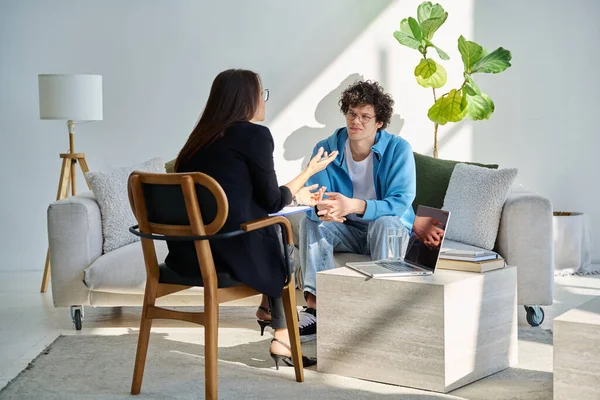 Akıl hastanesindeki genç adam profesyonel psikologla konuşuyor. Hasta ile çalışan kadın psikiyatrist danışmanı. Psikoloji psikiyatri tedavi desteği gençlere yardımcı oluyor