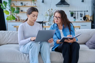 Dizüstü bilgisayarı olan genç bir kızla birlikte çalışan sosyal hizmet uzmanı bir kadın. Ev ziyareti anketi danışmanlığı. Psikolojik sosyal hizmetler, psikoterapi tedavisi desteği