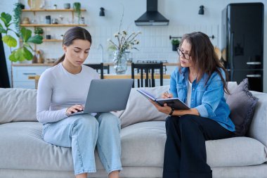 Dizüstü bilgisayarı olan genç bir kızla birlikte çalışan sosyal hizmet uzmanı bir kadın. Ev ziyareti anketi danışmanlığı. Psikolojik sosyal hizmetler, psikoterapi tedavisi desteği