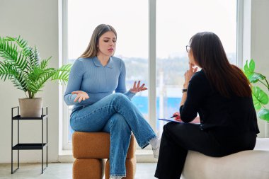 Terapi seansında psikoterapist psikolog psikanalist sosyal hizmet uzmanıyla konuşan genç bir kadın. Ruh sağlığı, profesyonel psikolojik danışmanlık, gençlik öğrencileri için sosyal hizmetler