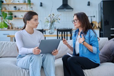 Dizüstü bilgisayarı olan genç bir kızla birlikte çalışan sosyal hizmet uzmanı bir kadın. Ev ziyareti anketi danışmanlığı. Psikolojik sosyal hizmetler, psikoterapi tedavisi desteği