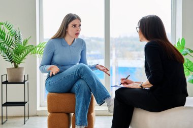 Terapi seansında psikoterapist psikolog psikanalist sosyal hizmet uzmanıyla konuşan genç bir kadın. Ruh sağlığı, profesyonel psikolojik danışmanlık, gençlik öğrencileri için sosyal hizmetler