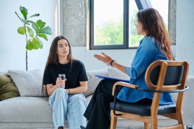 Psikolog terapistinin ofisinde ciddi bir genç kız. Genç bayan hasta psikoterapist sosyal uzmanıyla konuşuyor. Psikoloji psikoterapi zihinsel hizmetleri