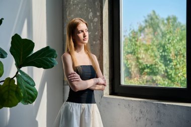 Kendine güvenen 18-20 yaşlarında genç bir kadının portresi. Pencerenin yanında, profil manzaralı, fotokopi odası olan. Güzel, modaya uygun, romantik, uzun saçlı bir kız. Gençlik yaşam tarzı güzellik modası