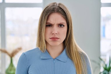 Evde poz veren çok üzgün bir genç kadının portresi. Güzel mutsuz, 20 'li yaşlarda, uzun sarı saçlı, kameraya bakan bir kadın. Güzellik, sağlık, yaşam tarzı, gençlik kavramı