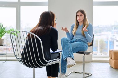 Genç bir kadın için profesyonel psikolojik destek. Hasta ve kadın terapist danışman sosyal hizmet görevlisi konuşması, terapi seansı. Psikoloji, psikoterapi, danışmanlık, ruh sağlığı hizmetleri.